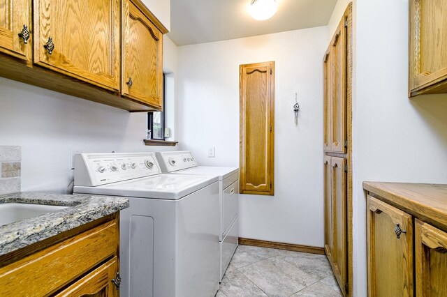 laundry area with washer and dryer and cabinets