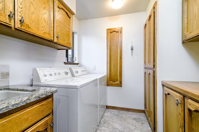 washroom with light tile patterned floors, cabinet space, independent washer and dryer, and baseboards