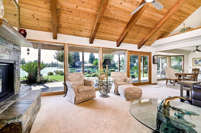 living room with light carpet, high vaulted ceiling, beam ceiling, wooden ceiling, and a stone fireplace