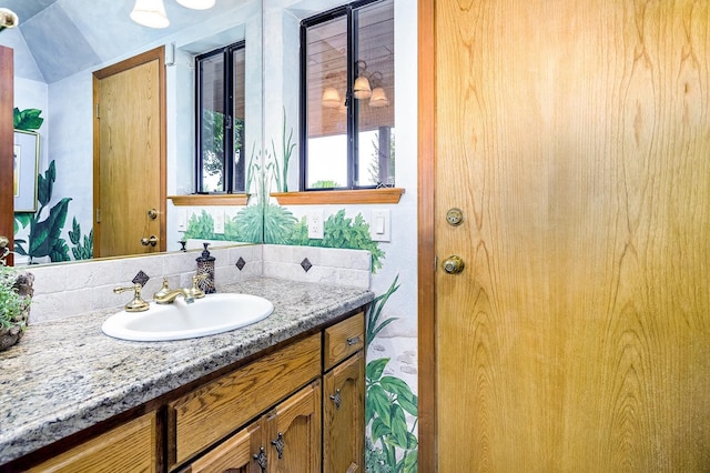 bathroom with vanity and vaulted ceiling