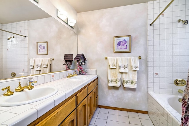 bathroom with tiled shower / bath combo, tile patterned floors, and vanity