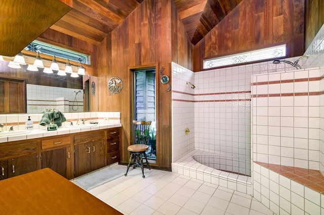 bathroom featuring lofted ceiling, wood walls, wooden ceiling, and a tile shower