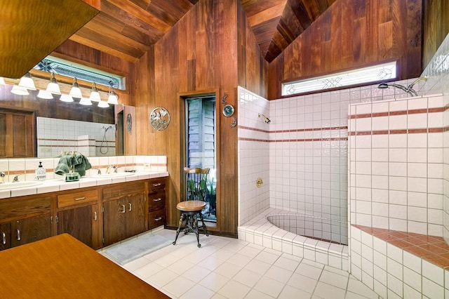 full bathroom with a wealth of natural light, tiled shower, lofted ceiling, and a sink