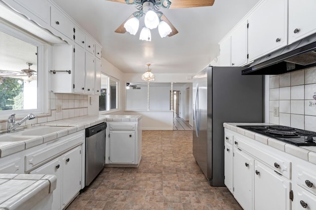 kitchen featuring appliances with stainless steel finishes, tasteful backsplash, white cabinets, sink, and tile countertops