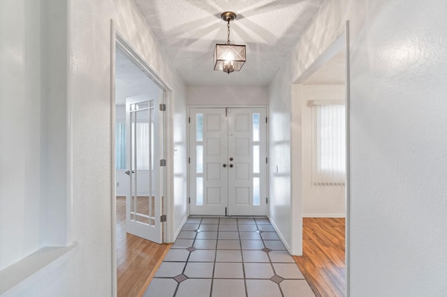 foyer entrance with a textured ceiling and wood-type flooring