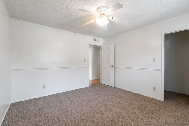 carpeted empty room featuring ceiling fan and a textured ceiling