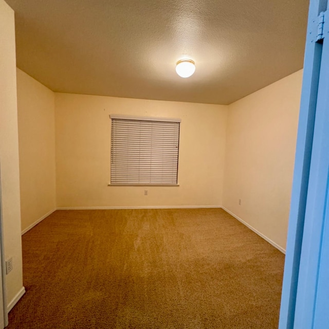 carpeted empty room with a textured ceiling