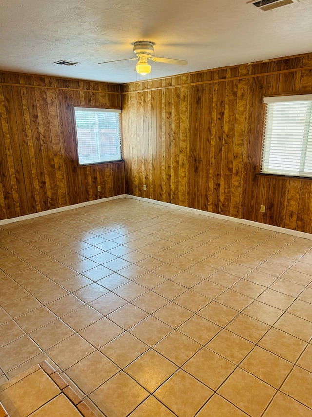 unfurnished room with wooden walls and ceiling fan