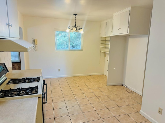 kitchen with white range with gas cooktop, hanging light fixtures, white cabinets, and light tile patterned floors