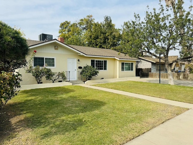 ranch-style home featuring cooling unit and a front yard