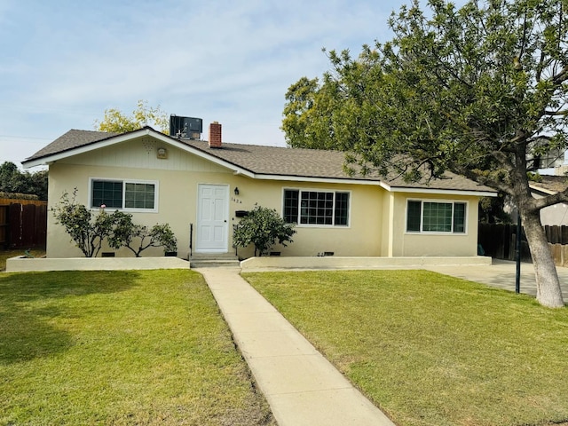 ranch-style house with central air condition unit and a front lawn