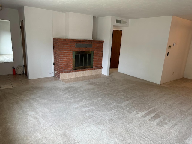 unfurnished living room with light carpet and a fireplace