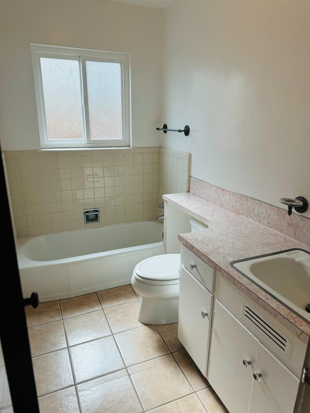 bathroom featuring vanity, a tub to relax in, tile patterned floors, and toilet