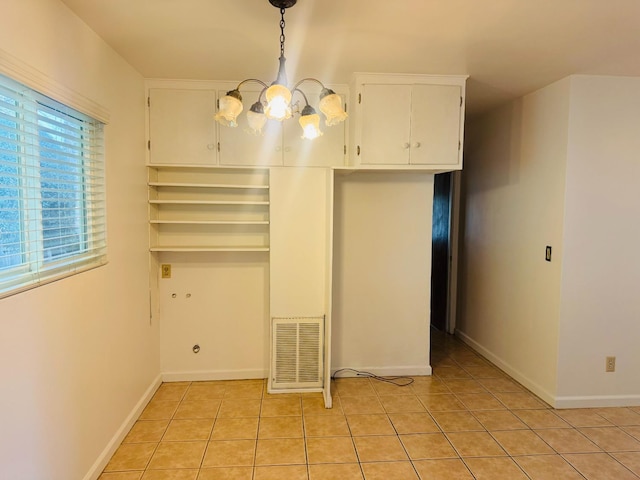 unfurnished dining area featuring a chandelier and light tile patterned flooring