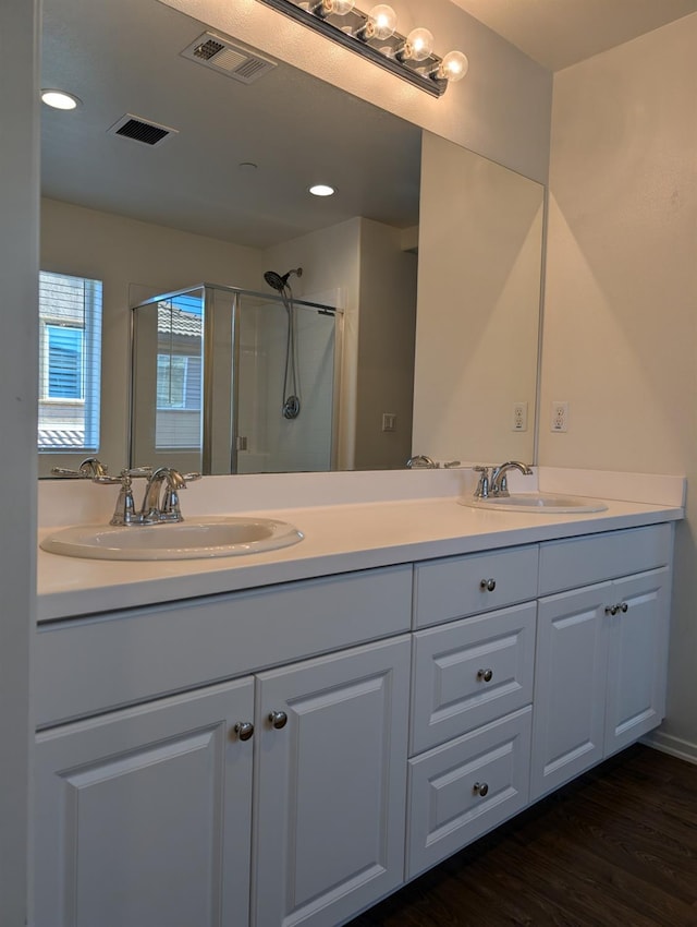 bathroom with vanity, an enclosed shower, and hardwood / wood-style floors