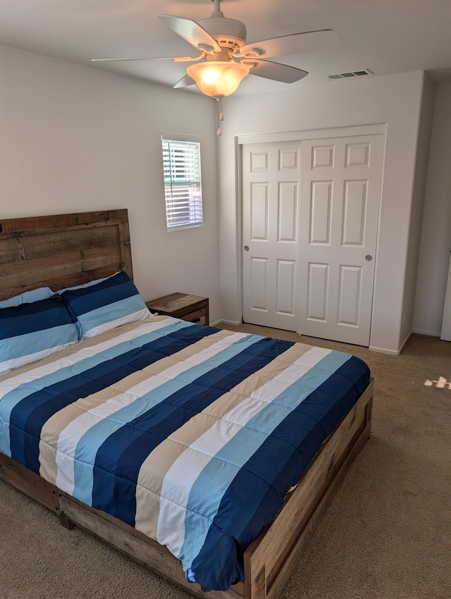 carpeted bedroom with ceiling fan and a closet