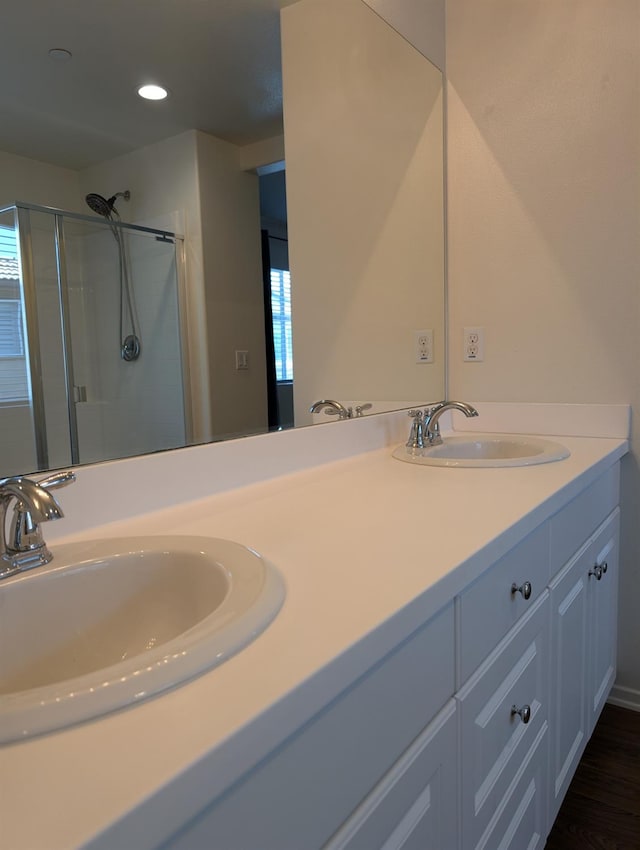 bathroom with a shower with door and vanity