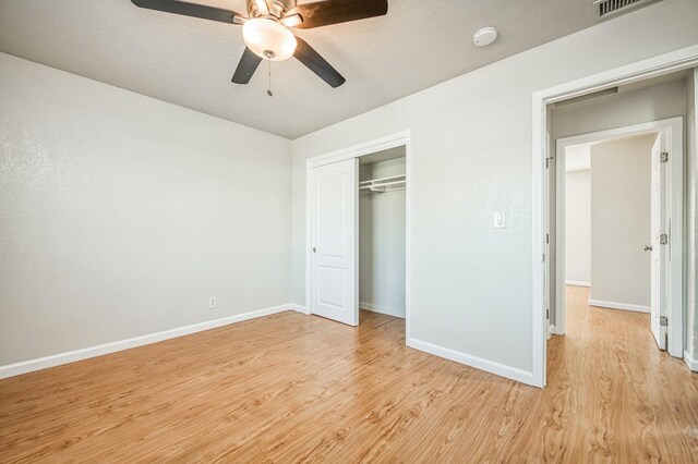 unfurnished bedroom featuring light wood-type flooring, ceiling fan, and a closet