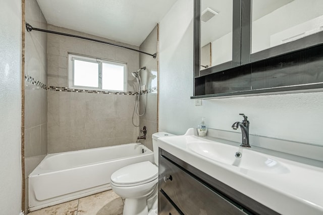 full bathroom with tile patterned flooring, tiled shower / bath, toilet, and vanity