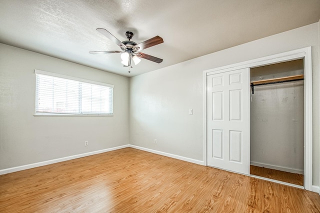 unfurnished bedroom featuring a closet, a textured ceiling, ceiling fan, and light hardwood / wood-style flooring