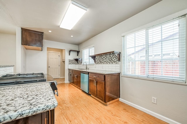 kitchen with light hardwood / wood-style floors, decorative backsplash, sink, stainless steel dishwasher, and light stone countertops