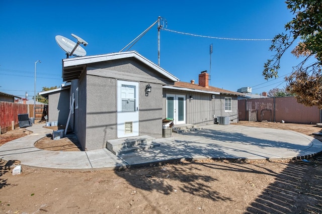 rear view of property featuring central AC unit and a patio