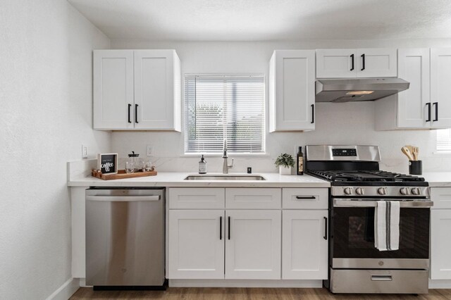 kitchen featuring light countertops, appliances with stainless steel finishes, white cabinets, and under cabinet range hood