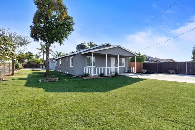 view of front facade with a porch, a front yard, fence, and stucco siding