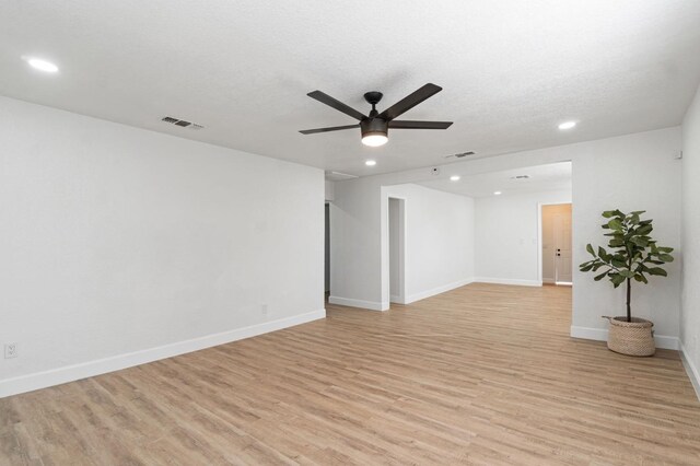 spare room featuring baseboards, a ceiling fan, light wood-style flooring, a textured ceiling, and recessed lighting