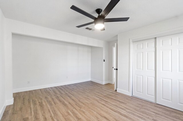 unfurnished bedroom with baseboards, a closet, visible vents, and light wood-style floors