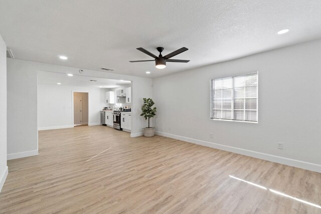 unfurnished living room with baseboards, visible vents, a ceiling fan, light wood-style floors, and recessed lighting