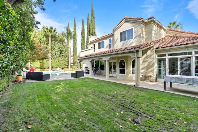 back of house with a yard and a patio