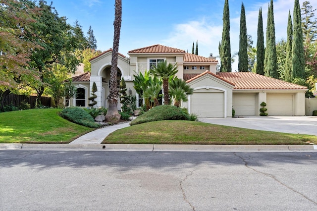 mediterranean / spanish home with a garage and a front lawn