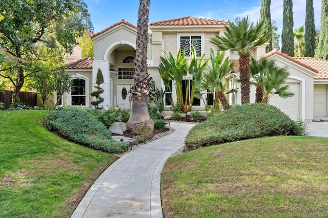 mediterranean / spanish-style house featuring a front yard and a garage