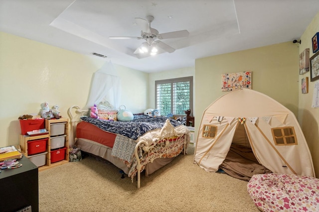 bedroom featuring carpet flooring, a raised ceiling, and ceiling fan