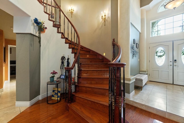 foyer featuring a high ceiling, light wood-type flooring, and french doors