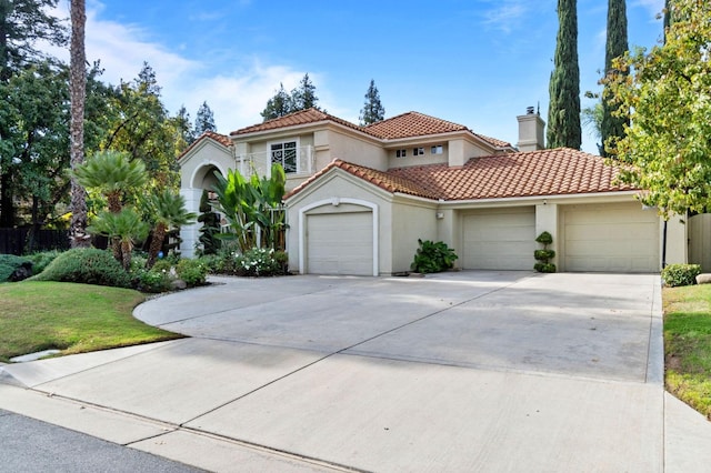 mediterranean / spanish-style home with a front lawn and a garage