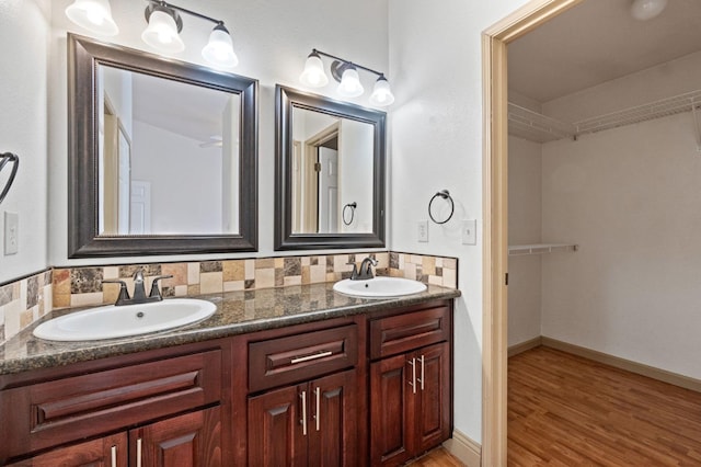 bathroom featuring hardwood / wood-style floors, vanity, and decorative backsplash