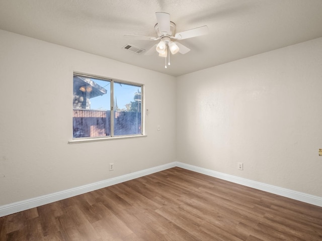 spare room featuring wood-type flooring and ceiling fan