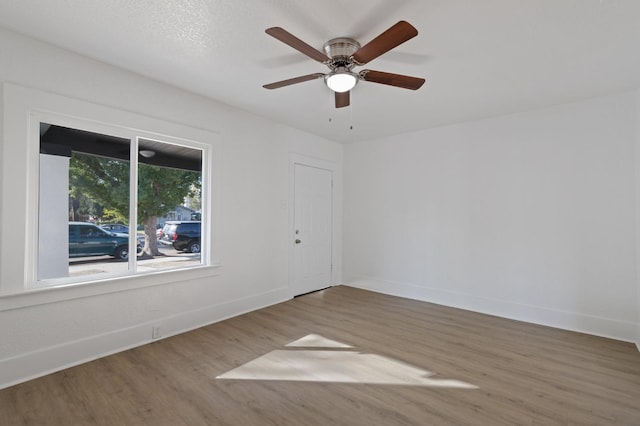 spare room featuring wood-type flooring, ceiling fan, and a textured ceiling