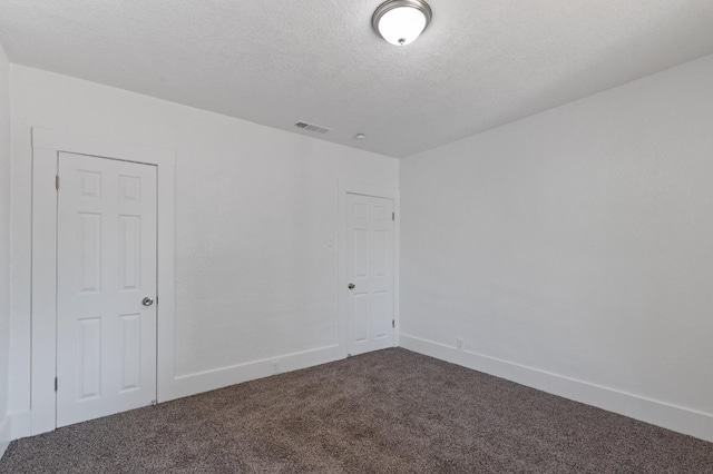 empty room with carpet and a textured ceiling