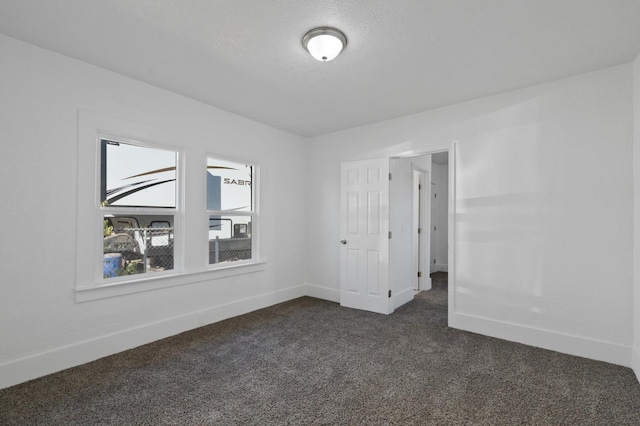 carpeted empty room featuring a textured ceiling