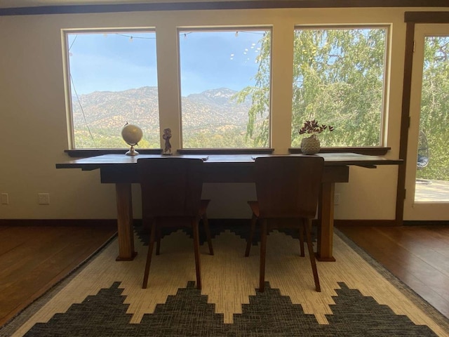 dining area with hardwood / wood-style flooring, a mountain view, and plenty of natural light