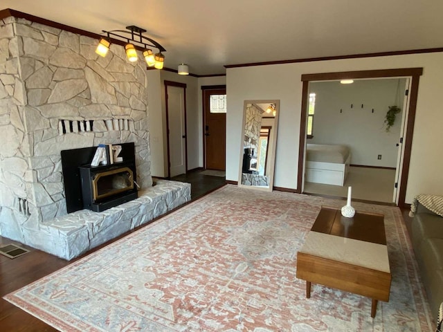 living room with hardwood / wood-style floors, ornamental molding, and a wood stove