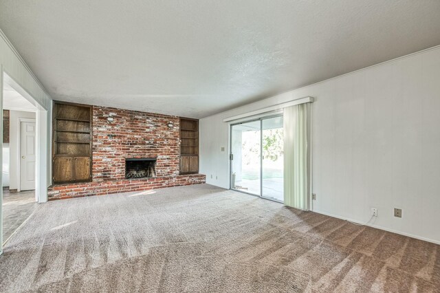 unfurnished living room featuring ornamental molding, a textured ceiling, a brick fireplace, built in features, and carpet floors