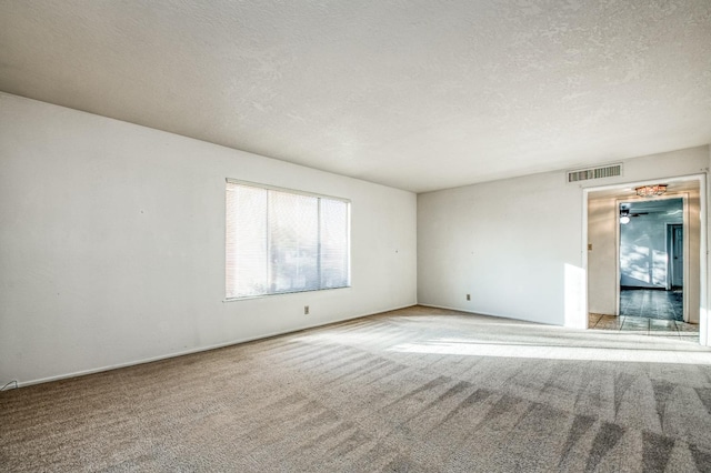 carpeted spare room with a textured ceiling