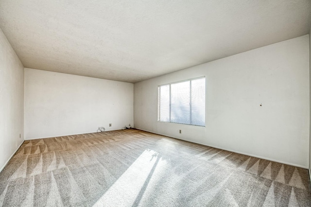 unfurnished room featuring carpet and a textured ceiling