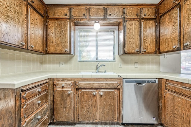 kitchen featuring tile counters, tasteful backsplash, stainless steel dishwasher, and sink