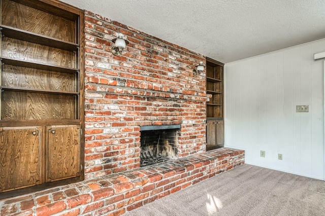 unfurnished living room with wood walls, a textured ceiling, light colored carpet, and a fireplace