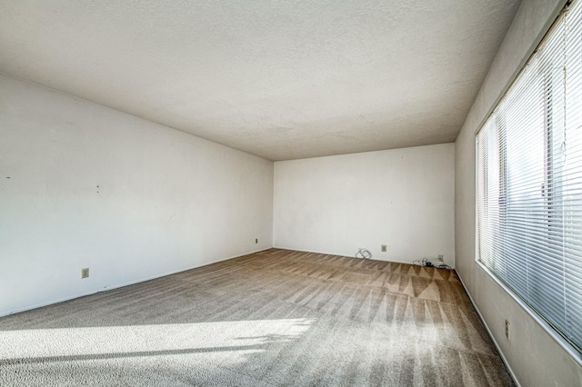 carpeted spare room with a textured ceiling